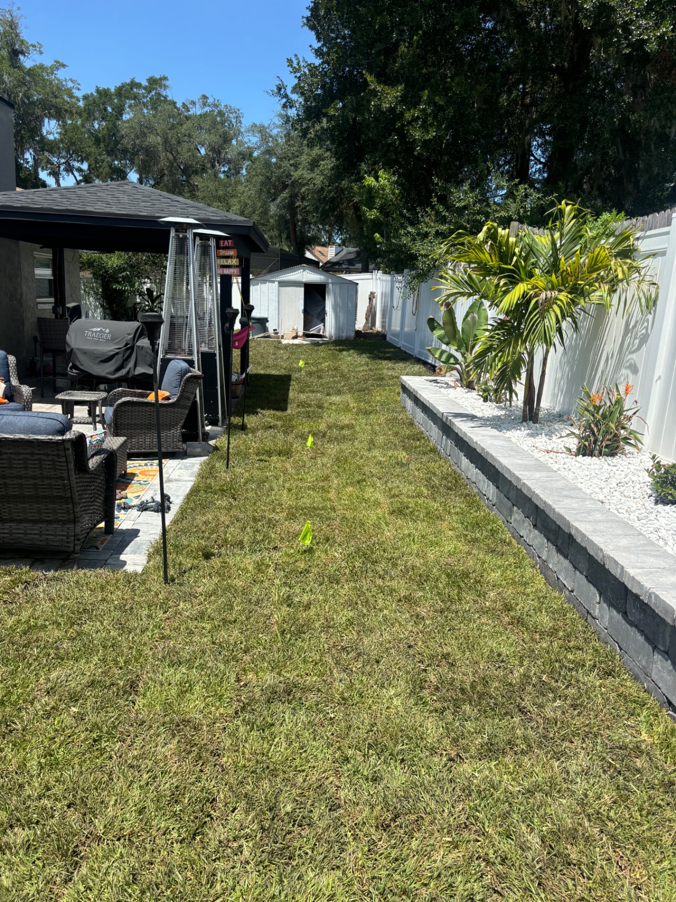 After — Dirt walkway transformed into sodded lawn with stacked stone retaining wall