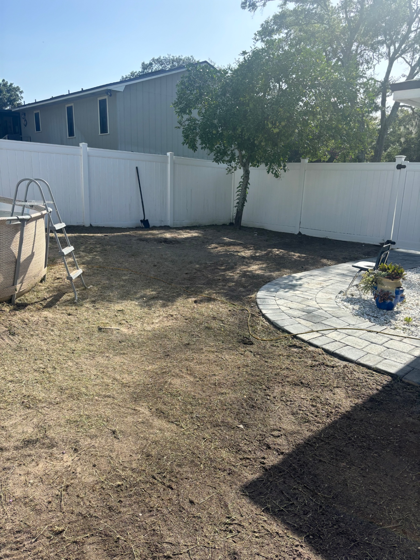 Before — Dirt yard around above-ground pool transformed into sodded lawn with paver patio