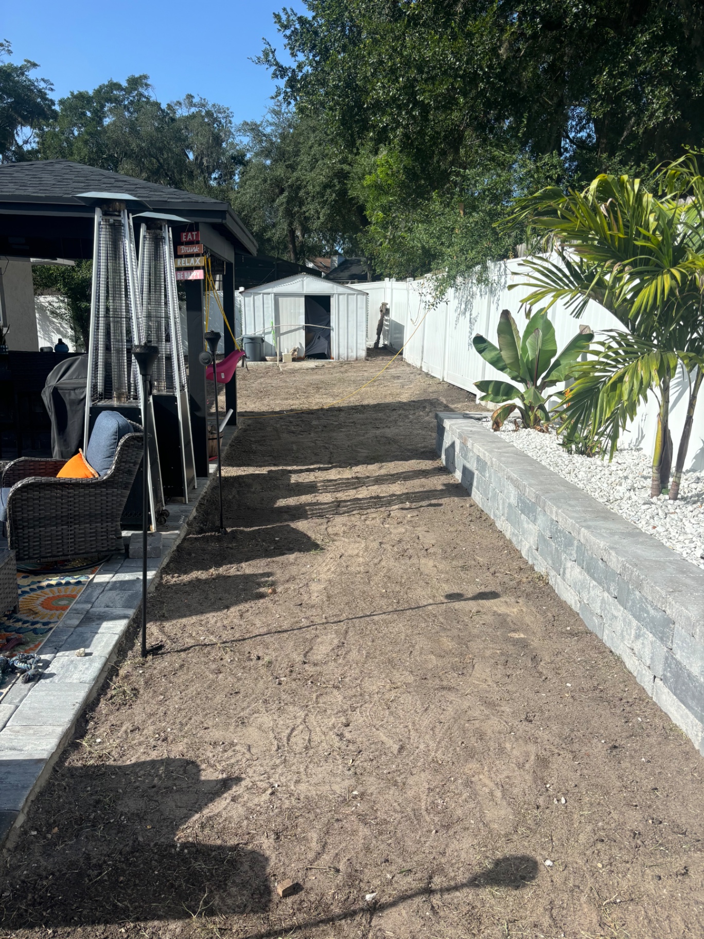Before — Dirt walkway transformed into sodded lawn with stacked stone retaining wall