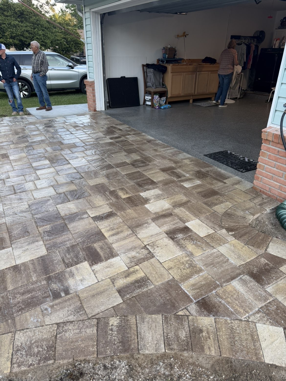 Close-up of tumbled paver driveway pattern leading into garage