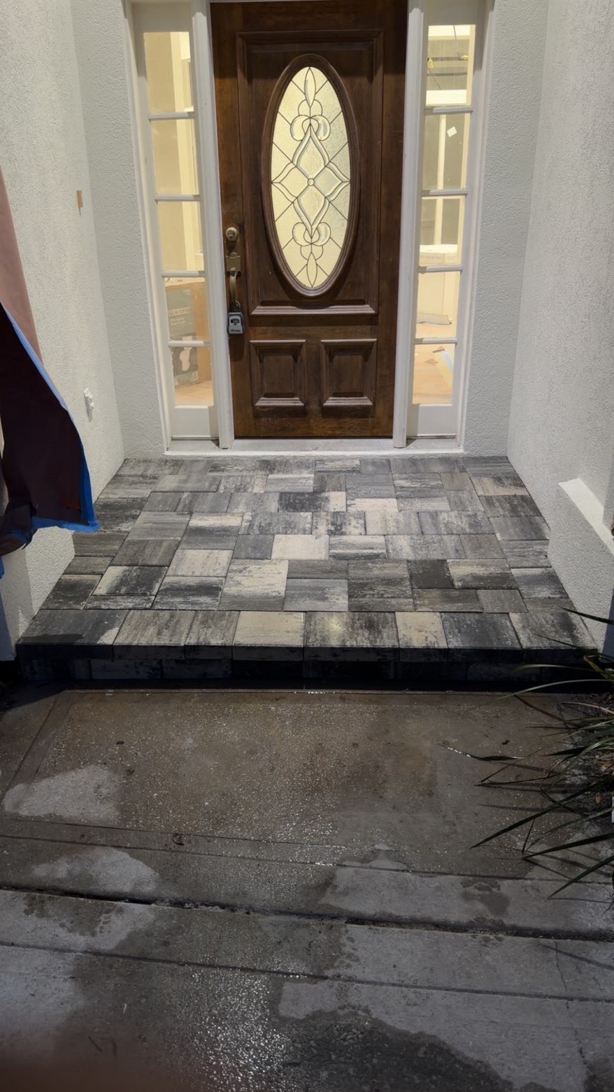 Gray-toned paver front entry stoop at a wooden front door